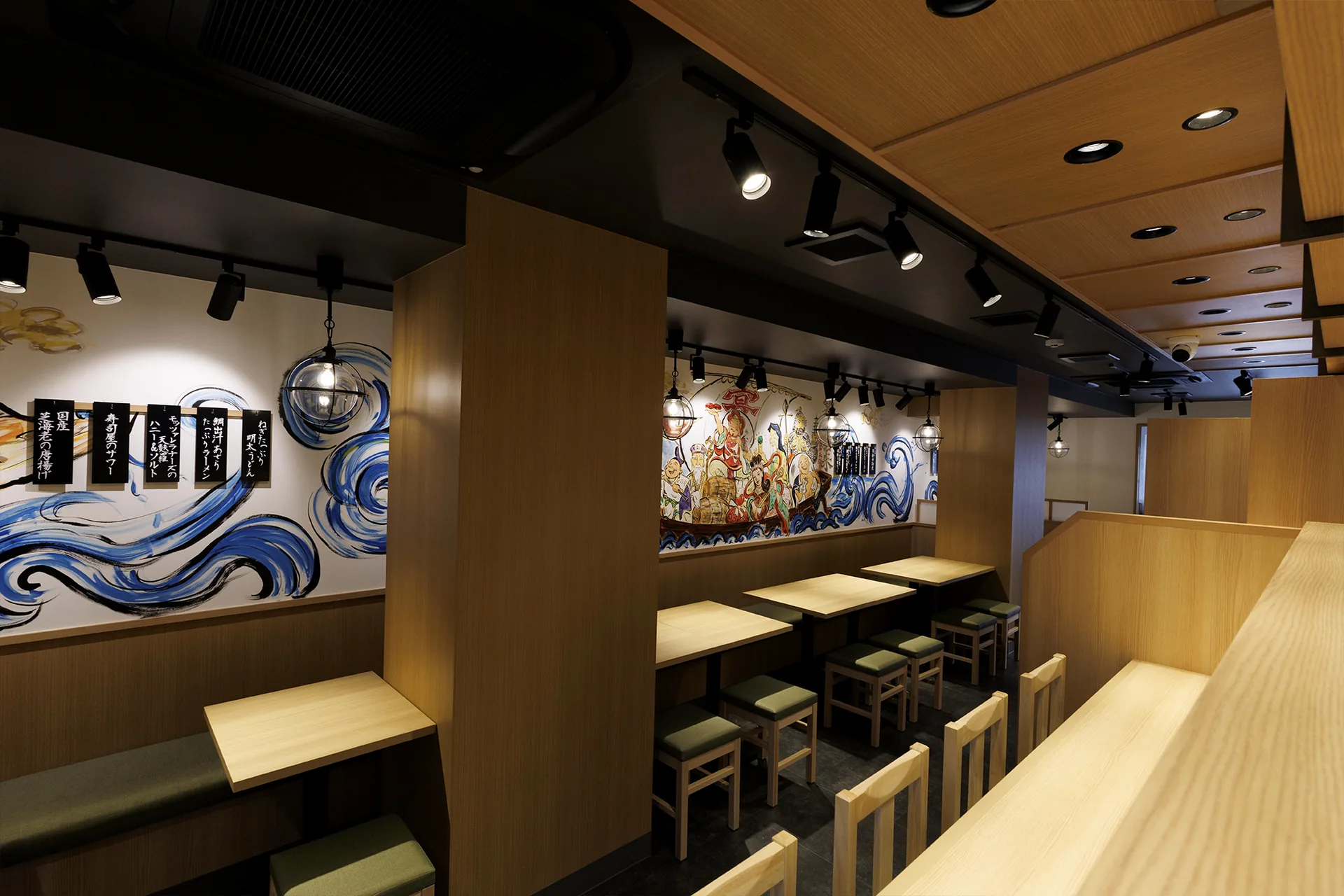 壁画に囲まれた明るい木目の店内とカウンター席