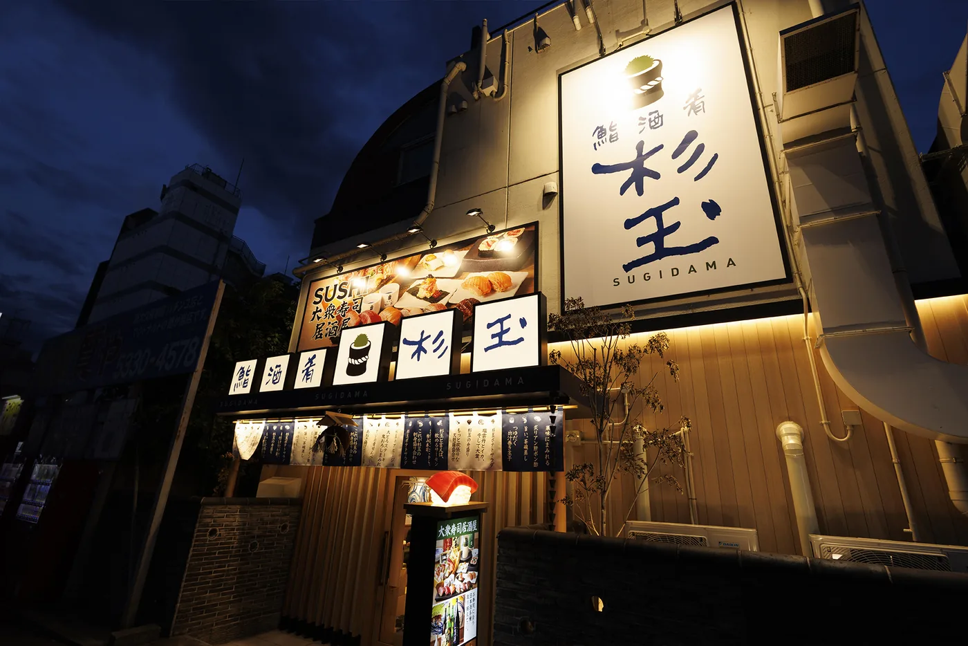 夜の通りに面した鮨 酒 肴　杉玉 新大久保の外観